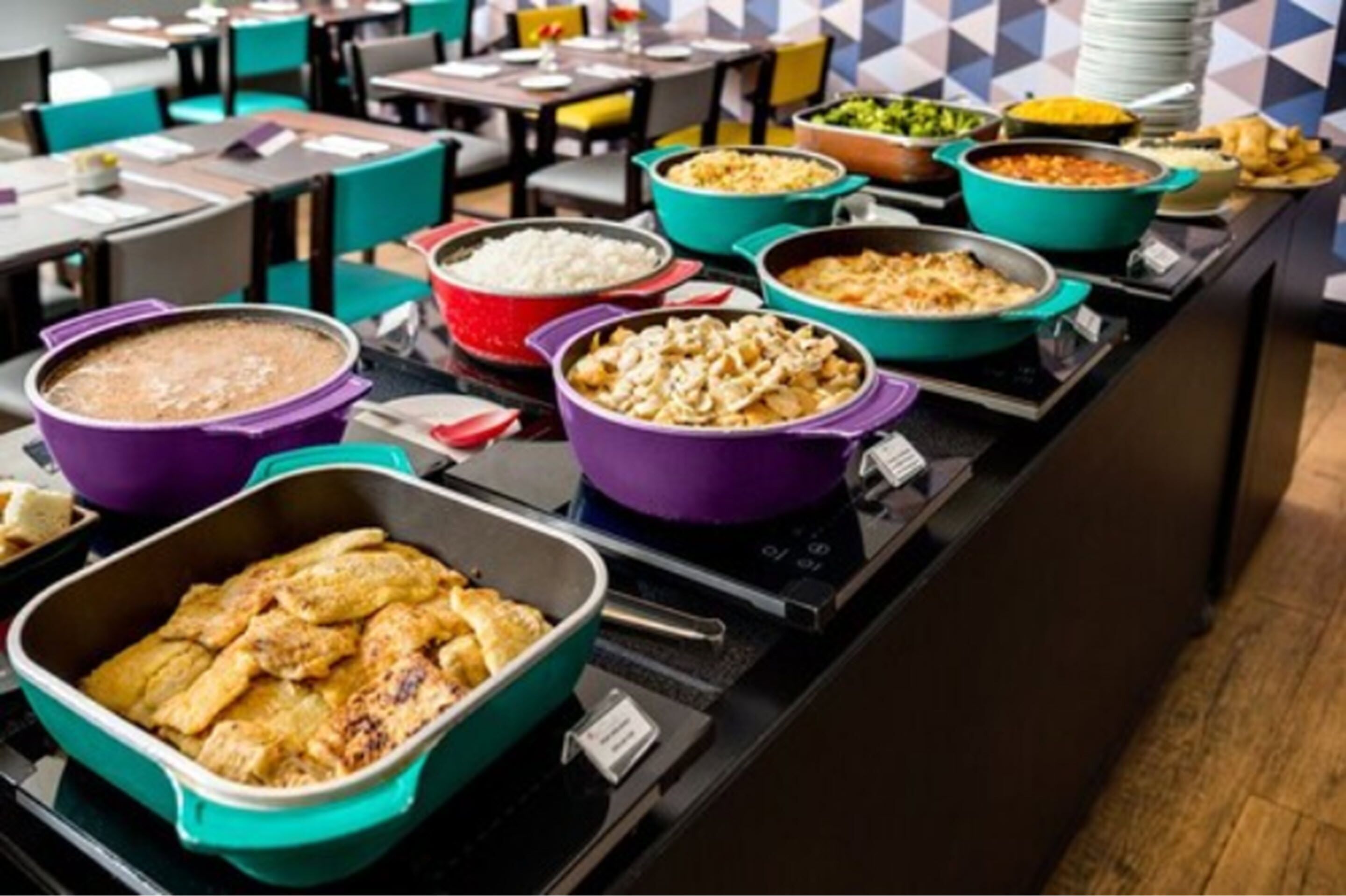 Un buffet proposant divers plats présentés dans de jolis plats de service aux couleurs vives.