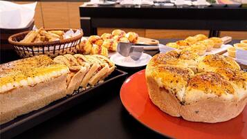 A buffet with various baked goods including bread and pastries.