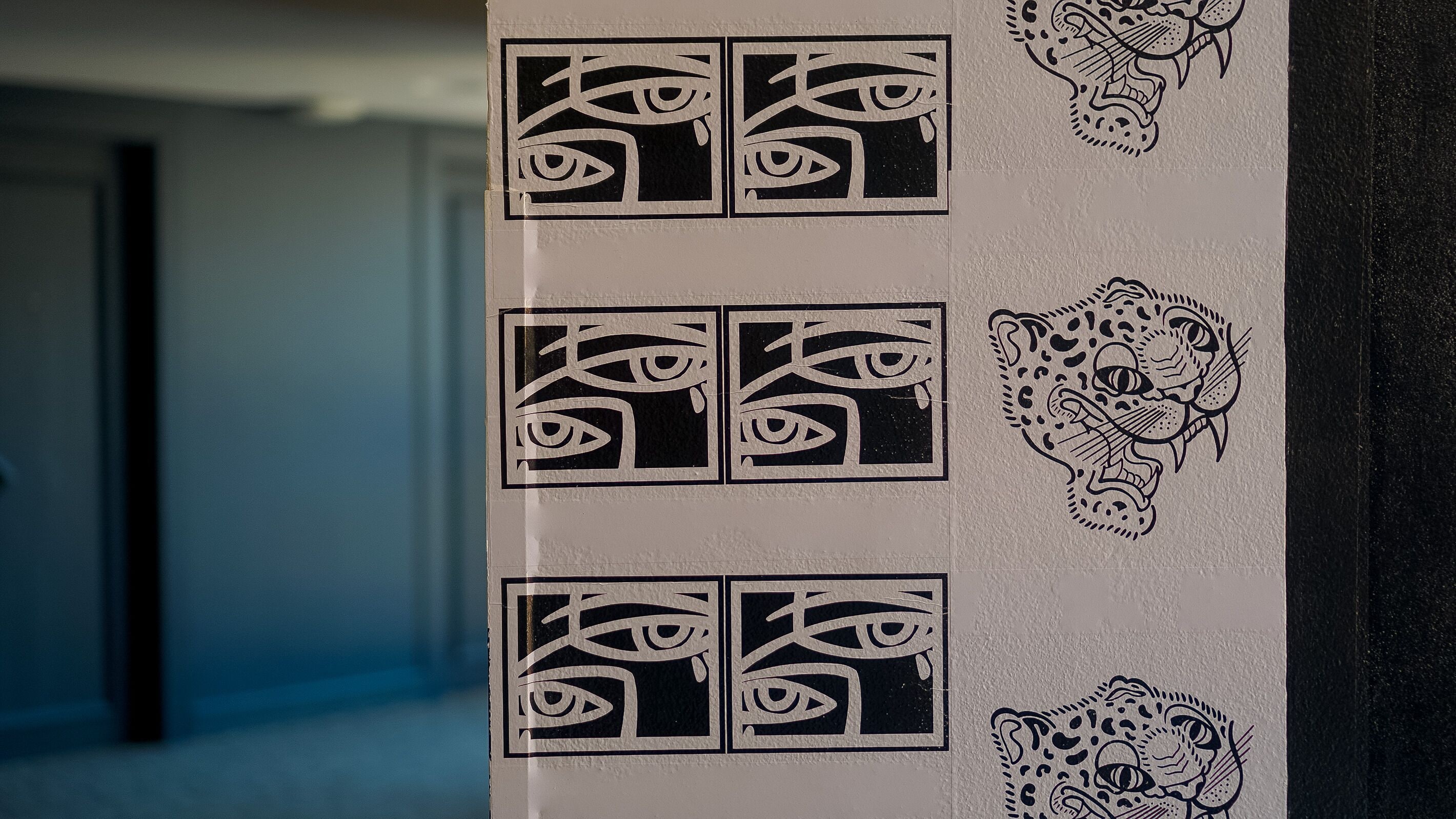 A wall with repeated geometric patterns and a leopard face design.