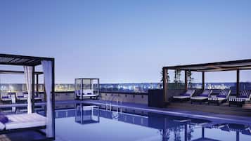 Una piscina al aire libre, camas de piscina gratis, sombrillas