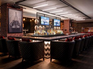 A bar area with a long counter, multiple televisions, and a variety of bottles. - Pullman Dubai Creek City Centre (Dubai)