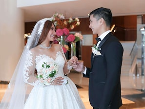 A wedding ceremony with a bride and groom exchanging rings in a modern hotel lobby. - Pullman Dubai Creek City Centre (Dubai)