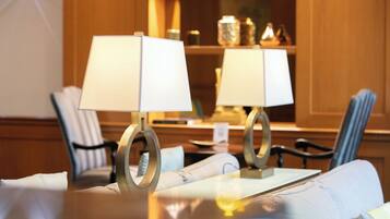 A dining area with two tables, each with a lamp and chairs.