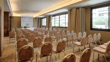 A conference room with rows of chairs, a podium, and a banner.