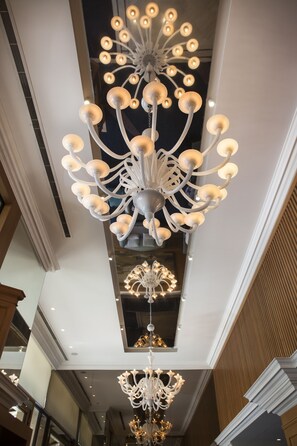 Un gran candelabro con varios niveles y luces, un techo alto y un diseño de interiores moderno.