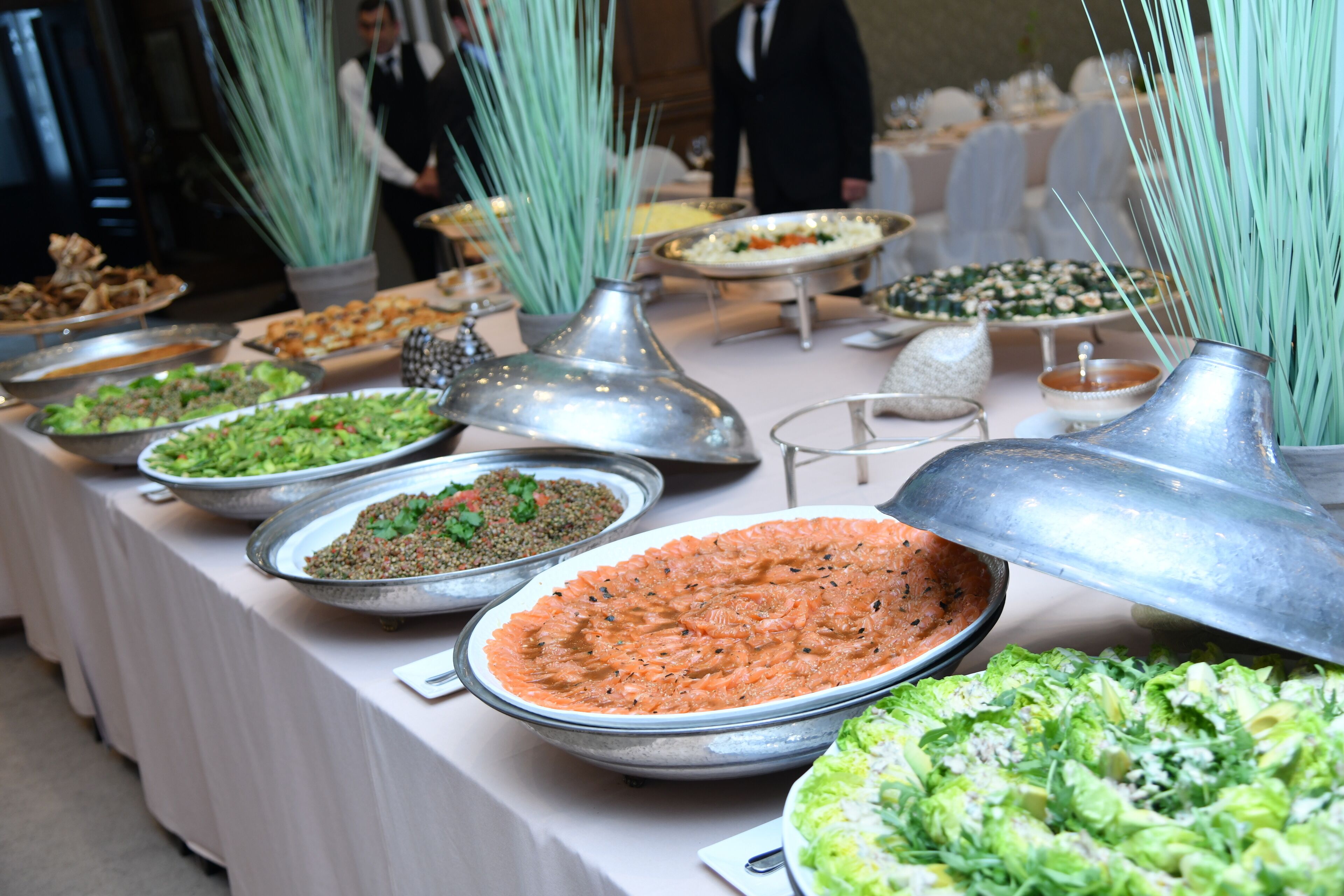 A buffet table with various food items and decorative elements.