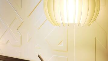 A wall with geometric patterns and a hanging light fixture.