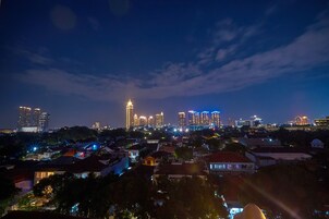 A nighttime cityscape with illuminated buildings and a mix of residential and commercial structures.