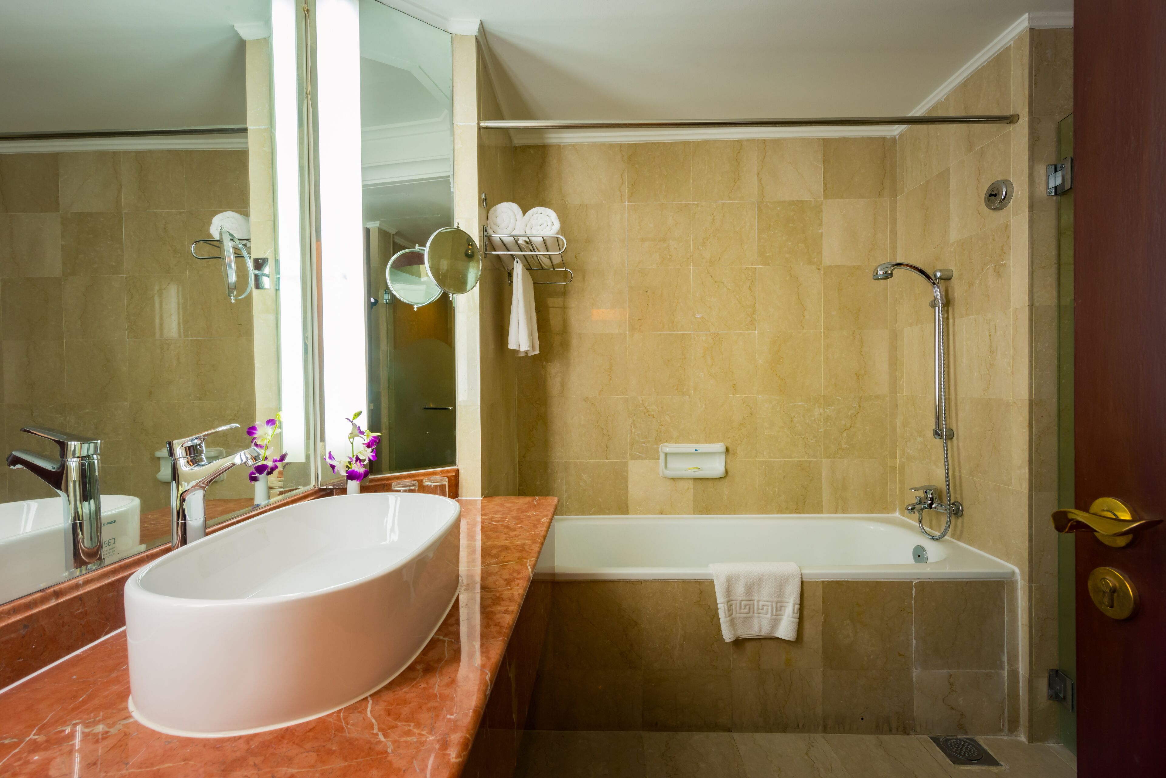 Un baño con un lavamanos ovalado grande, una bañera y una ducha.