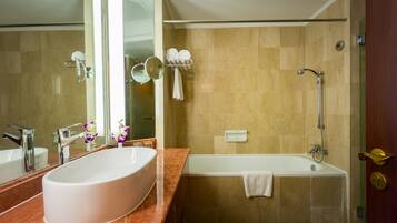 Un baño con un lavamanos ovalado grande, una bañera y una ducha.