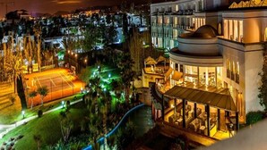A modern hotel with a large pool, outdoor seating area, and a well-lit facade. - Marina Smir Hotel & Spa (Allyene)
