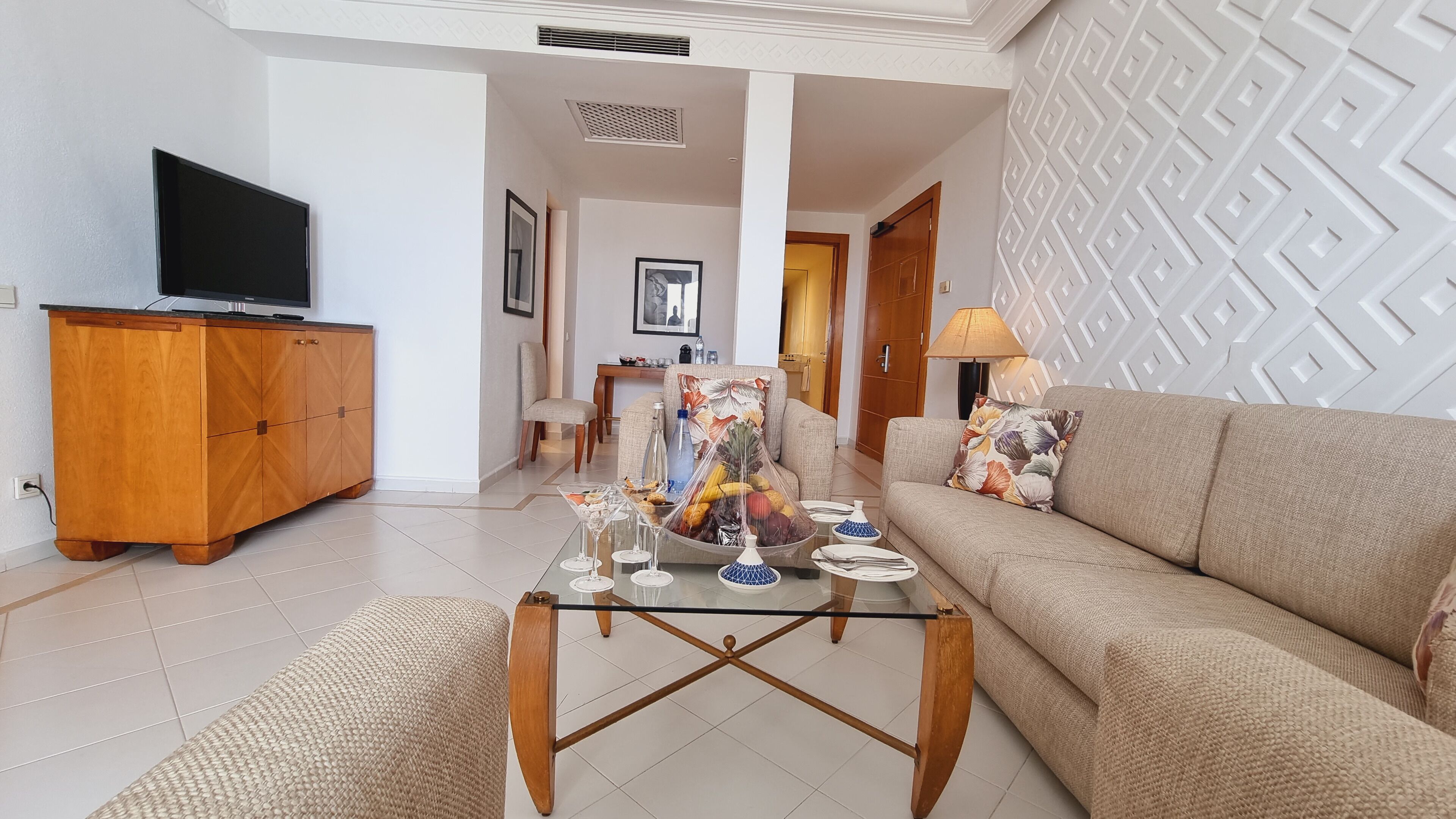 Una sala de estar moderna con sofá, mesa de centro y televisor.