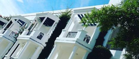 Un edificio de varios pisos con fachadas blancas y balcones.