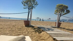 A sandy beach with a wooden pathway leading to a beach umbrella. - Marina Smir Hotel & Spa (Allyene)