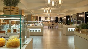 A modern hotel lobby with a central reception area, multiple seating arrangements, and a bakery counter. - Almar Timi Ama Villasimius (Villasimius)
