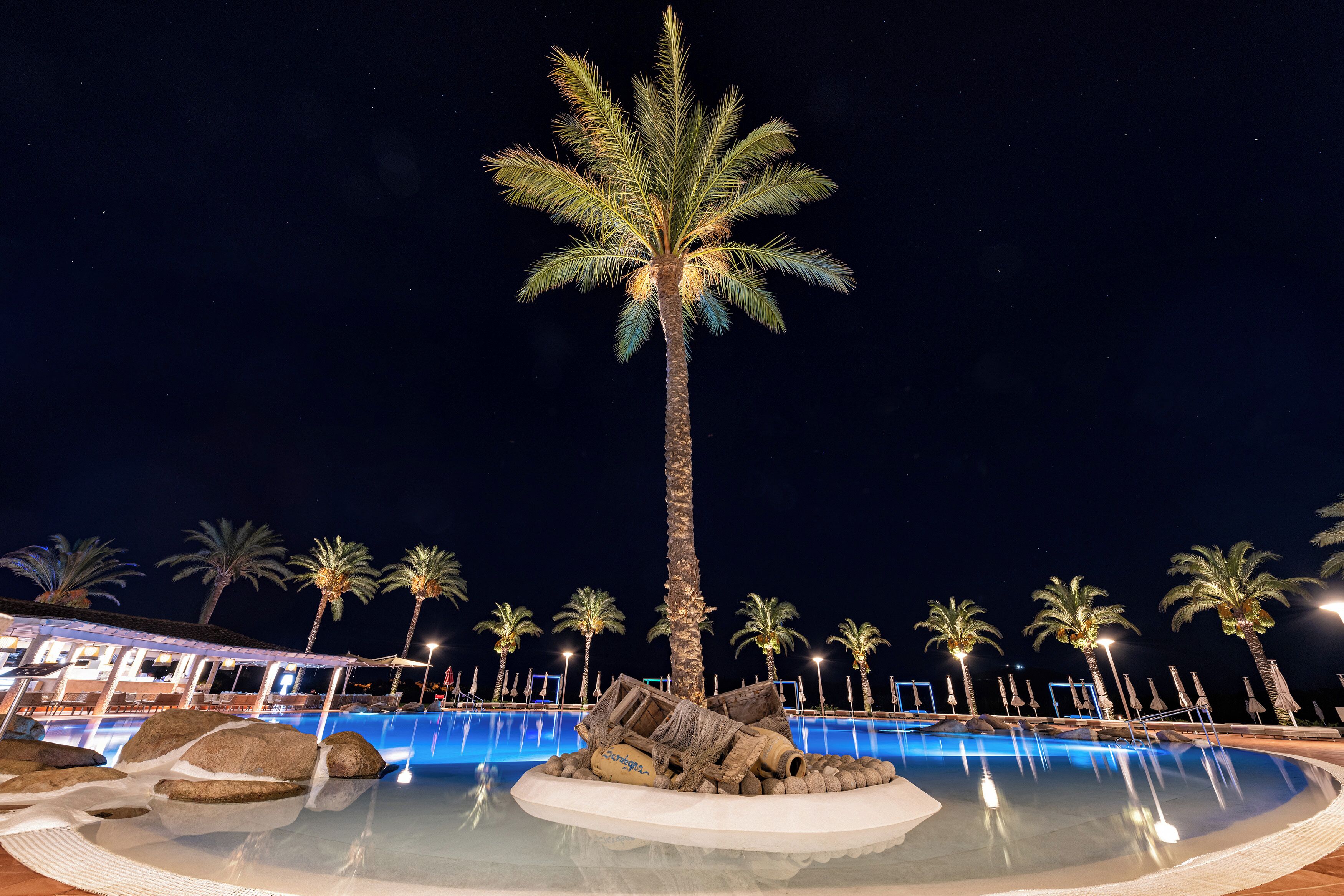 Una piscina al aire libre, sombrillas, sillones reclinables de piscina