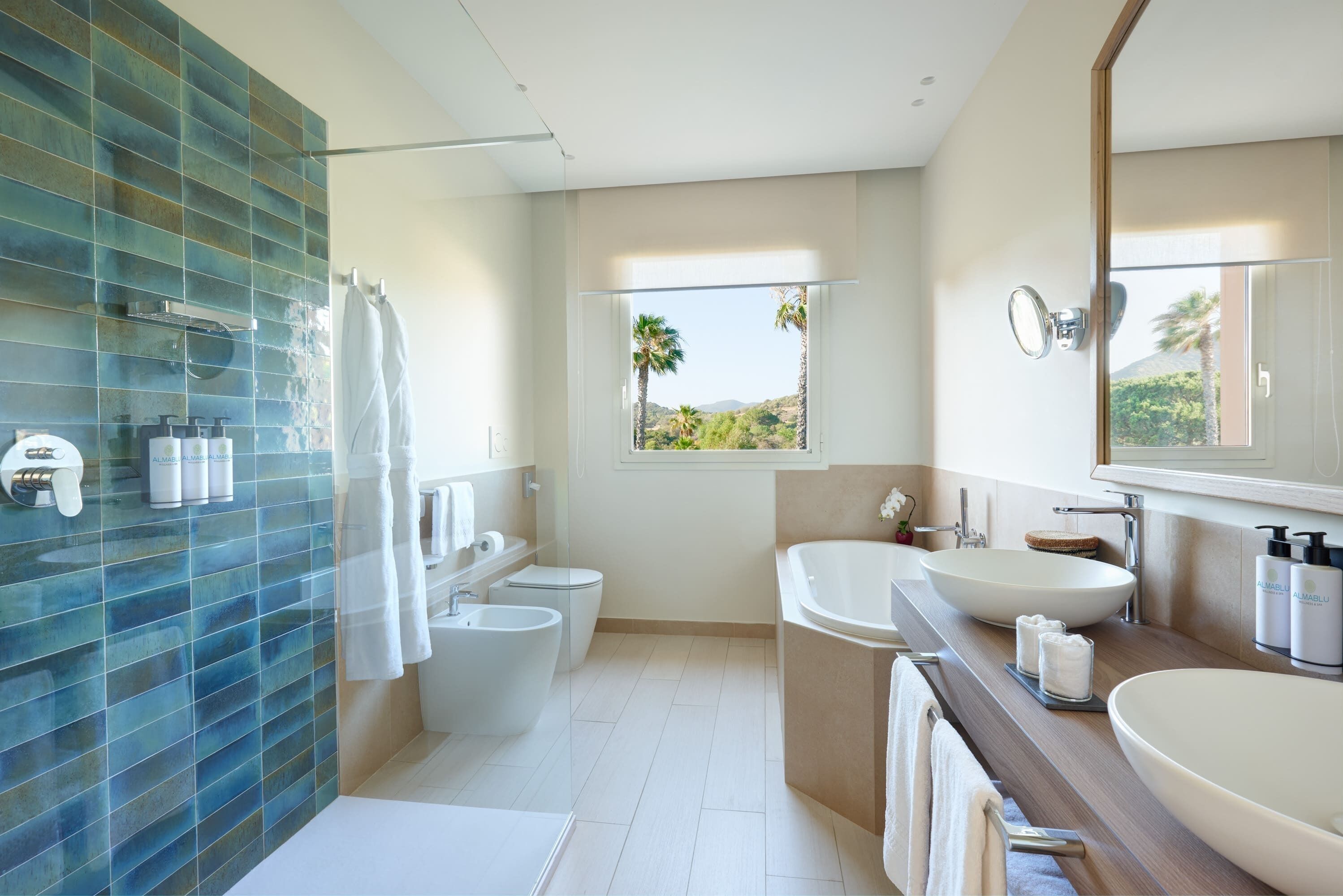 Un baño moderno con una bañera grande, un lavamanos independiente y una zona de ducha con paredes de vidrio.