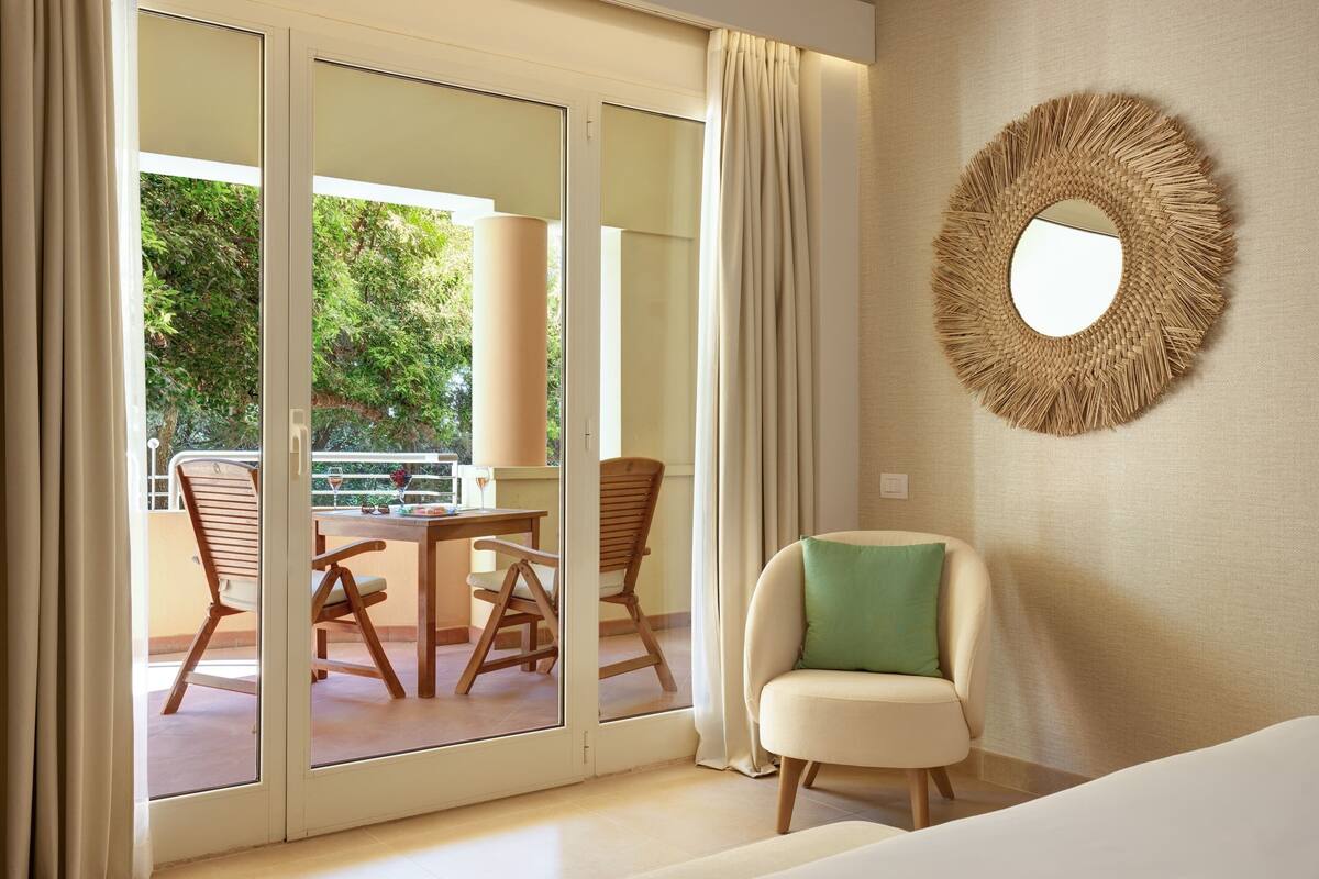 A room with a sliding glass door leading to an outdoor area with a table and chairs.