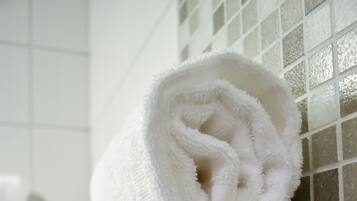 Two white towels stacked on a dark wooden surface.