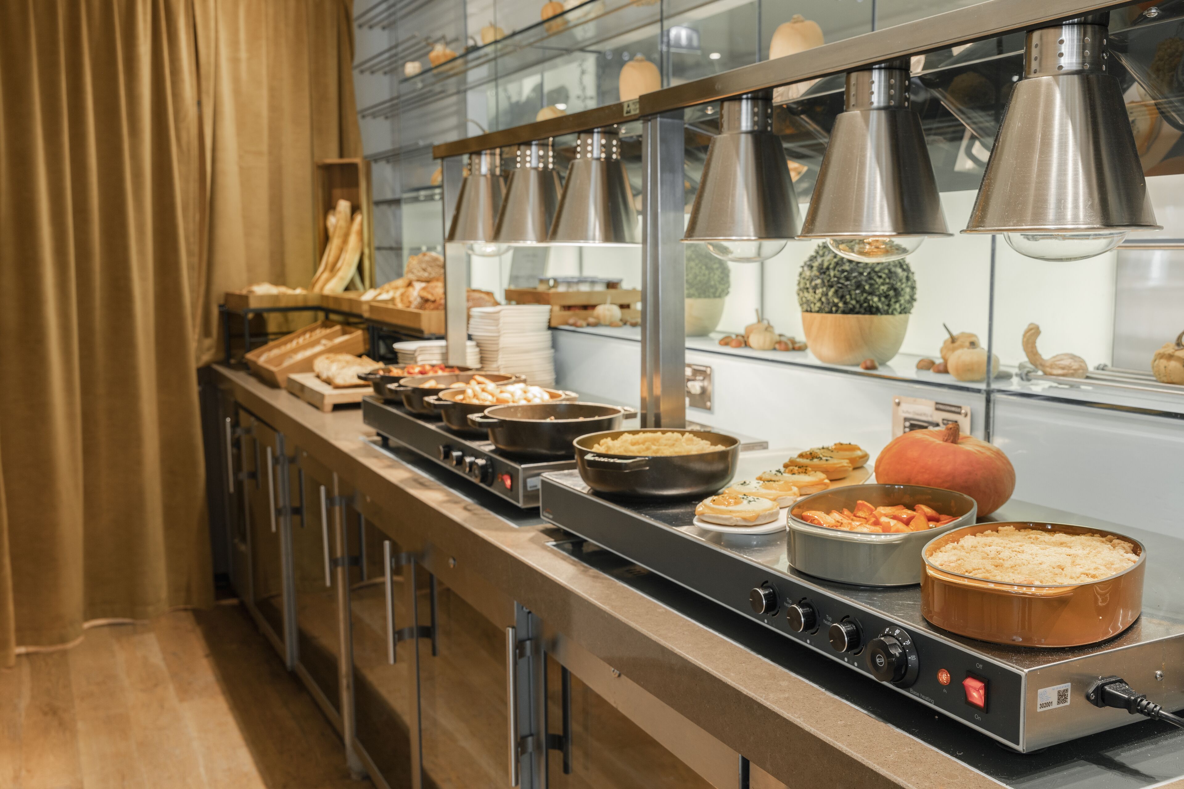 A buffet setup with various dishes, a large pumpkin, and a stove with control knobs.