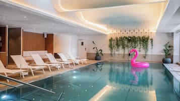 Een binnenzwembad en ligstoelen