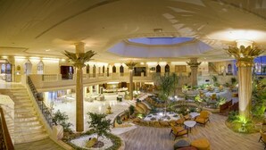 A spacious lobby with a central fountain, multiple seating areas, and a staircase leading to upper floors.