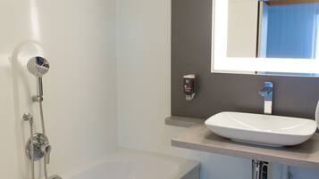 Een moderne badkamer met een bad, een wastafel en een spiegel.