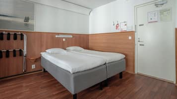 Una camera con un letto singolo, una testiera in legno, un comodino e una mensola a parete.
