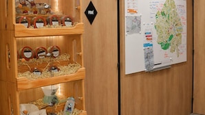 A wooden cabinet with jars of honey, a map on the wall, and a 'PRIVÉ' sign. - ibis Styles Caen Centre Historique (Caen)