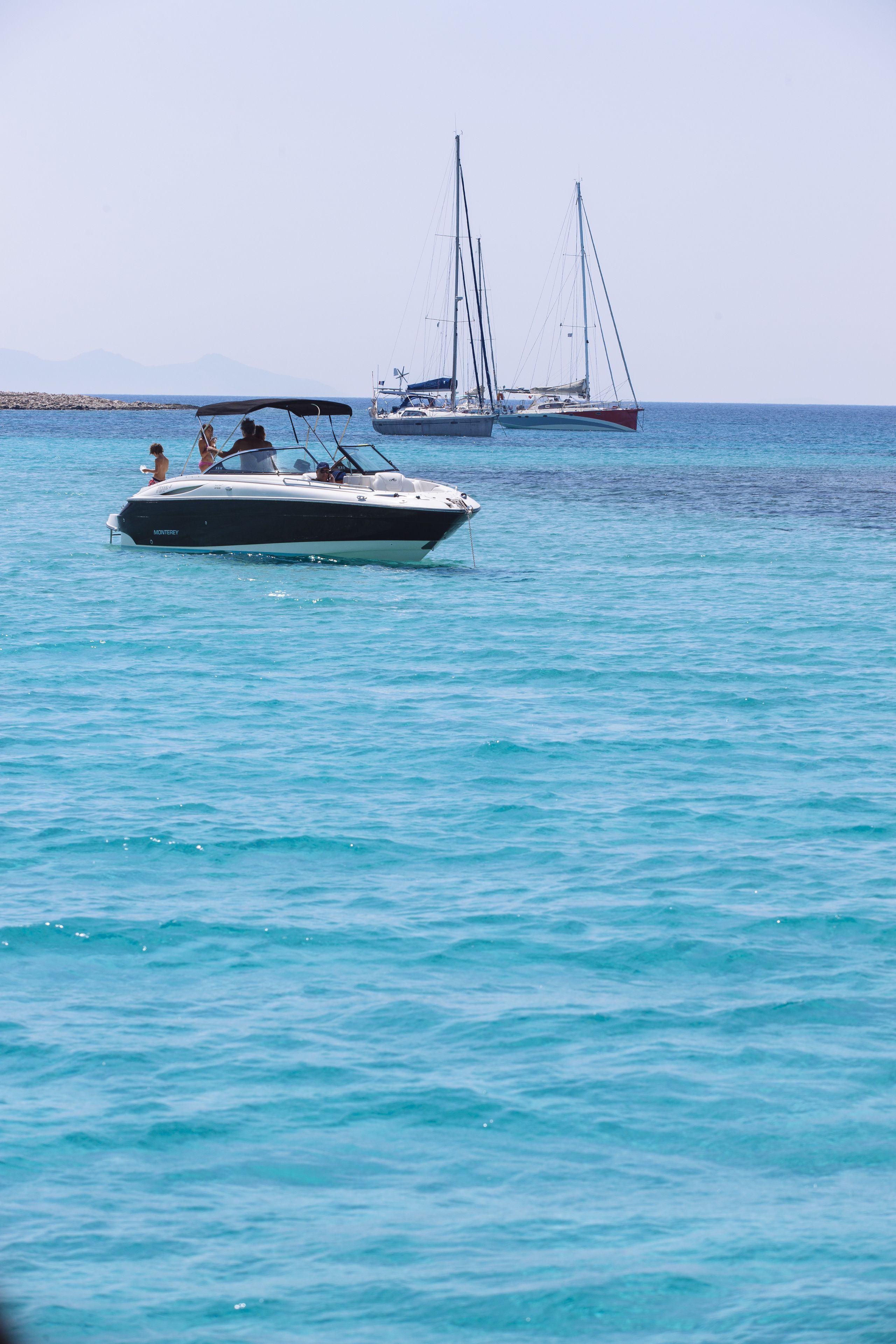 A boat on calm water with a clear sky.