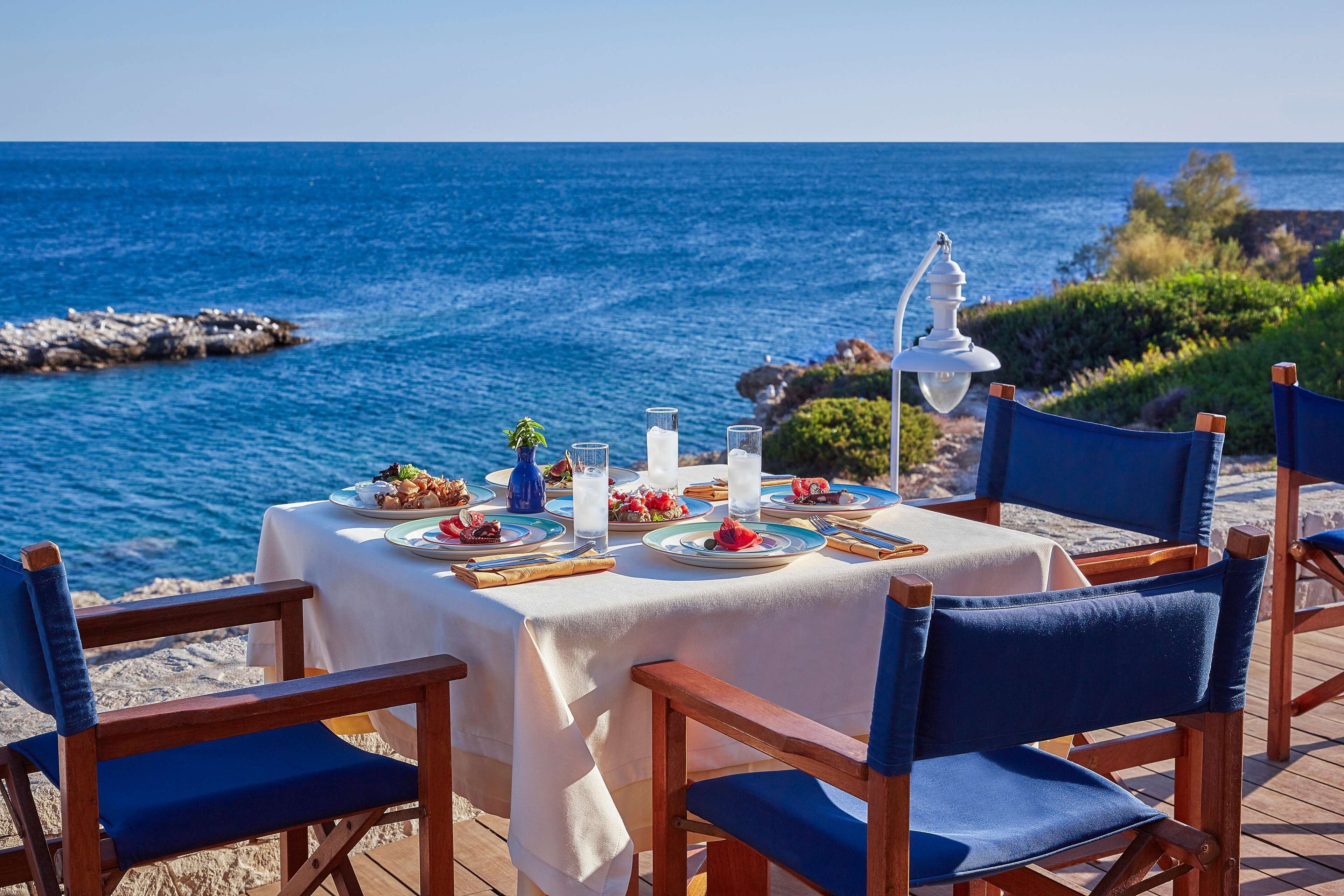 Una mesa preparada para una comida con vistas al mar.