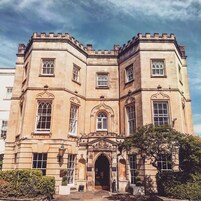 A historic building with a symmetrical facade, large windows, and a central entrance with an archway.