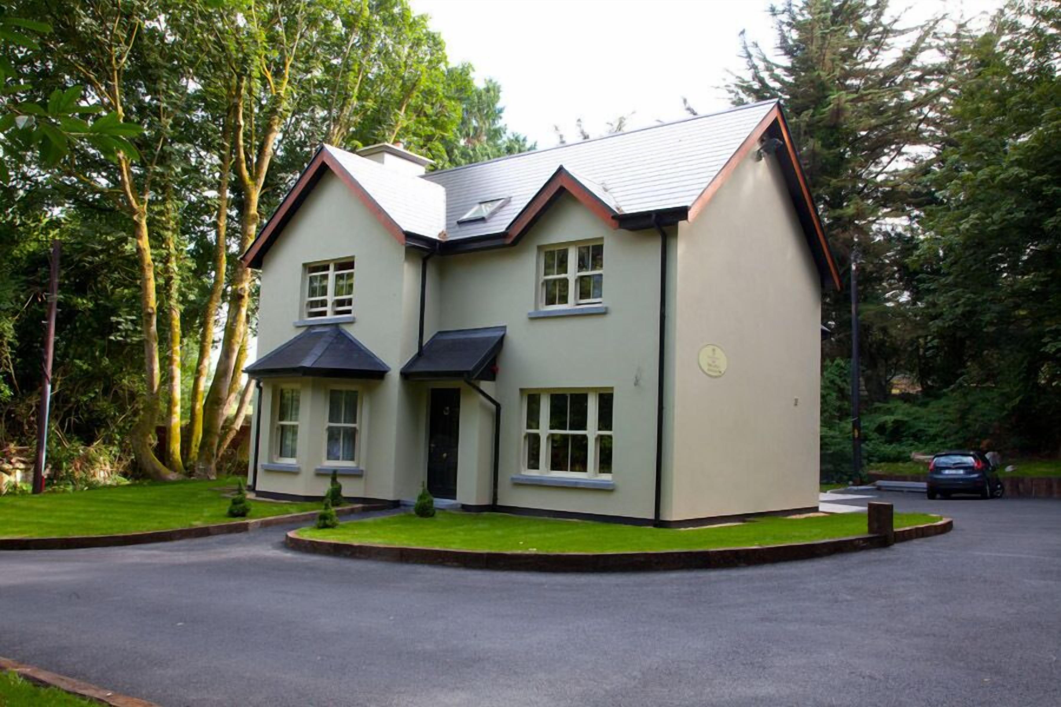 A two-story house with a sloped roof, a front porch, and a driveway.