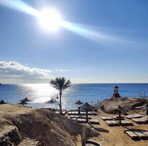 Playa privada, camas de playa, sillas reclinables de playa, sombrillas