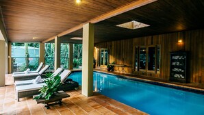 A poolside area with lounge chairs and a wooden ceiling. - Daintree Ecolodge (Lower Daintree)
