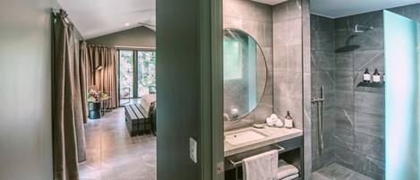 Un baño moderno con un espejo grande, ducha y tocador.
