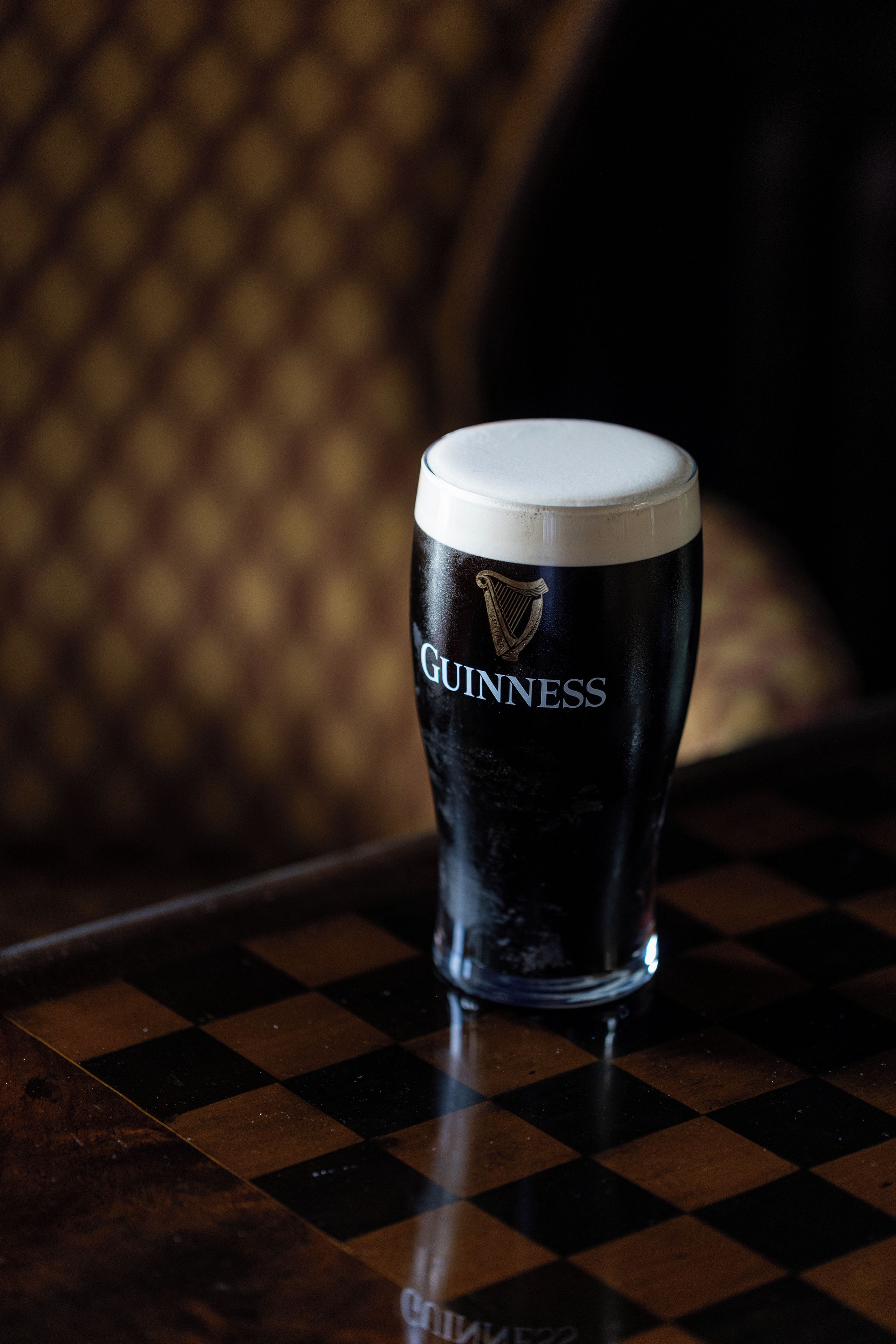 Un vaso de Guinness sobre una mesa a cuadros.