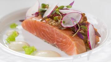 A plate of food with salmon, radishes, and greens.
