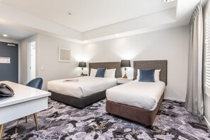 A hotel room with two beds, a desk, and a chair. - Hotel Kingsley (Hamilton)