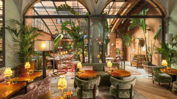 A hotel lobby with arched ceilings, indoor plants, and seating areas. - J And J Historic House Hotel (Florence)