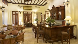 A hotel lobby with a bar area, wooden furniture, and ceiling fans. - Settha Palace Hotel (Vientiane)