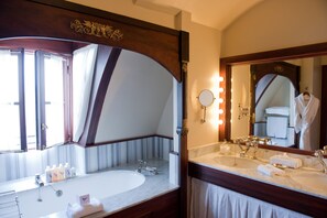 A bathroom with a large mirror, two sinks, and a vanity area.