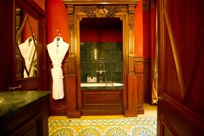 A bathroom with a wooden vanity, a mirror, a towel rack, a sink, and a bathtub. - L'Hotel (Paris)