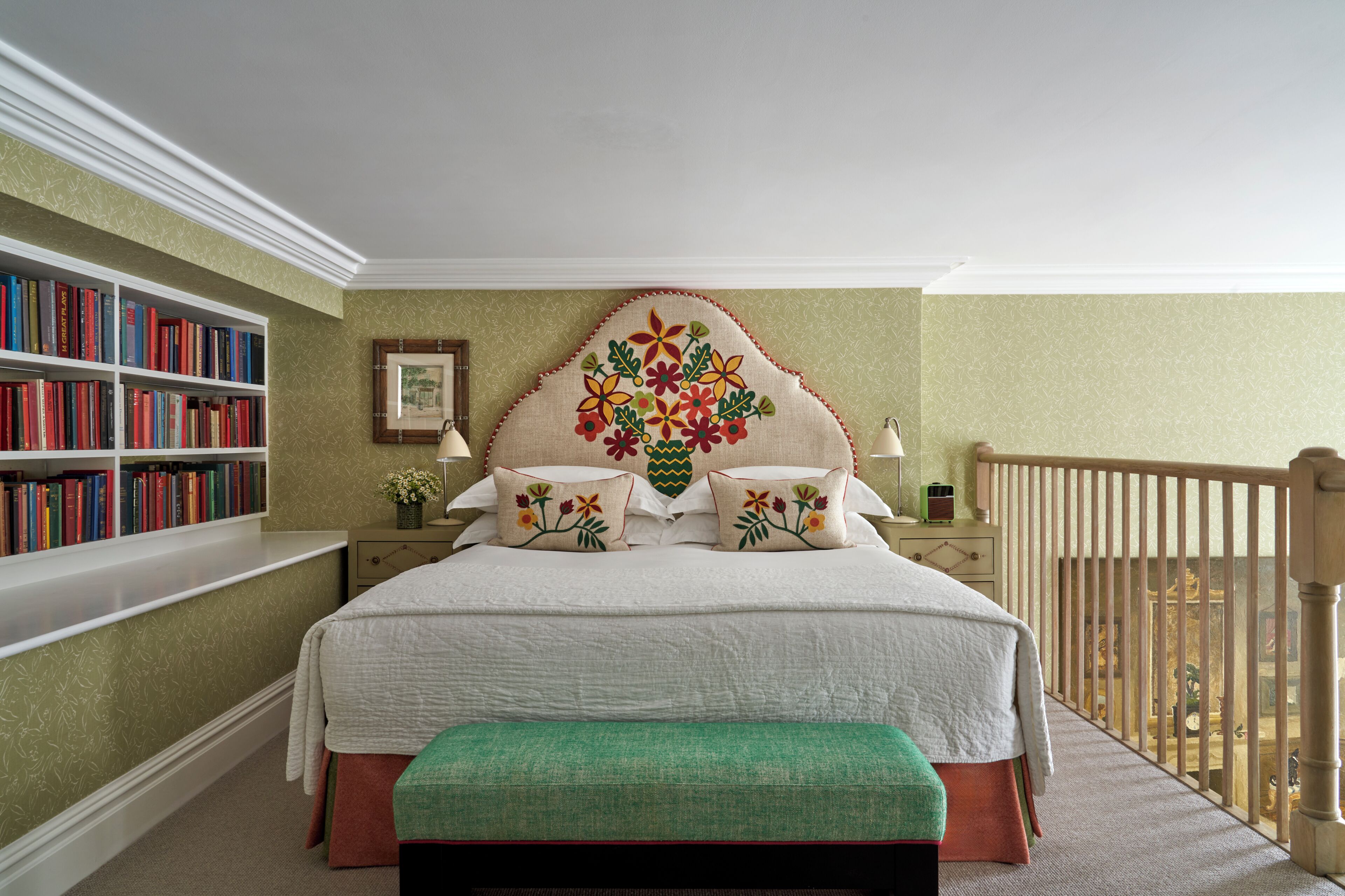 A bedroom with a bed, a bookshelf, a nightstand, and a view of the balcony.