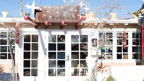 A building with a sign reading "Las Palomas" and a dove symbol. It has multiple windows and a white facade. - Las Palomas (Santa Fe)