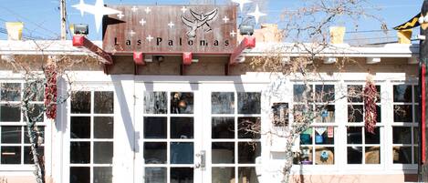 A building with a sign reading "Las Palomas" and a dove symbol. It has multiple windows and a white facade.