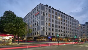 A multi-story hotel with a modern facade, multiple balconies, and a prominent signage. - Scandic Malmen (Stockholm)