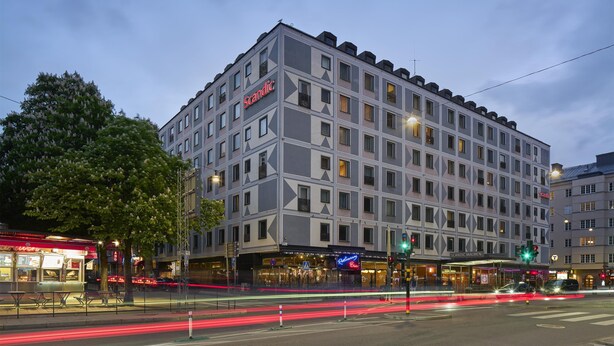 A multi-story hotel with a modern facade, multiple balconies, and a prominent signage. - Scandic Malmen (Stockholm)