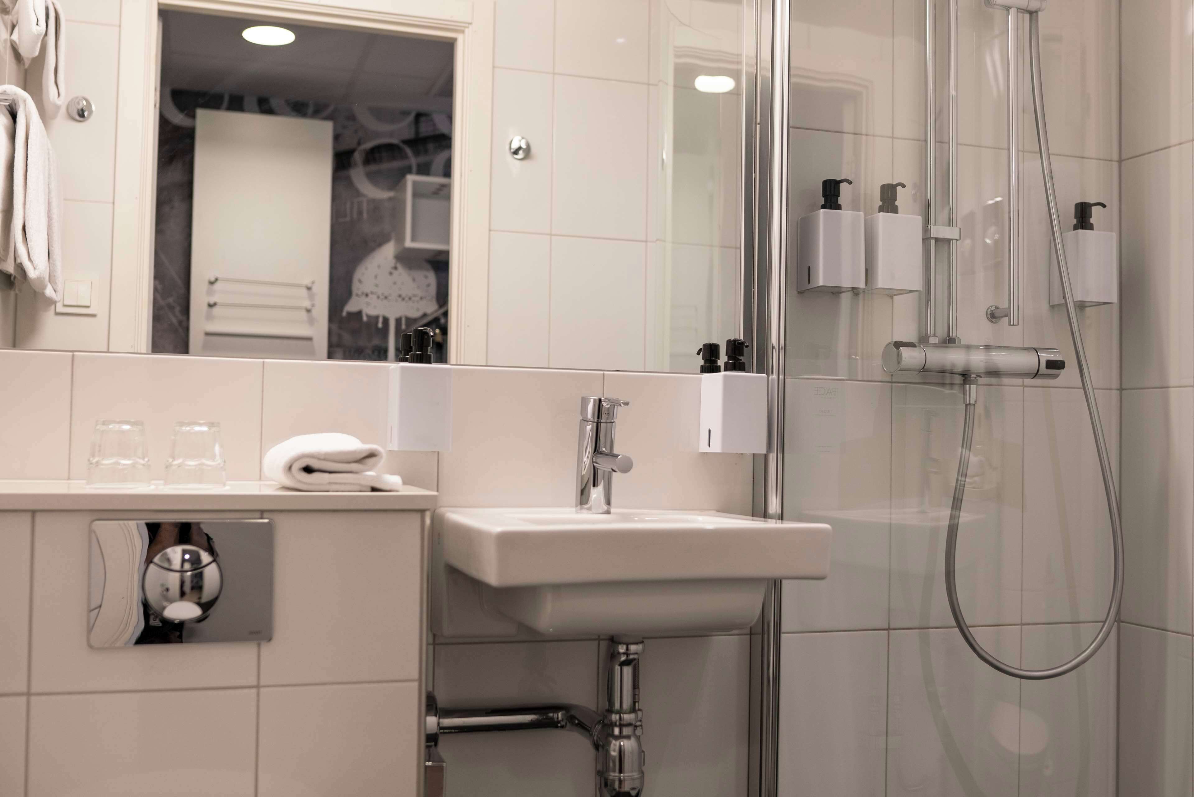 Une salle de bain moderne avec un lavabo, un miroir et une douche.