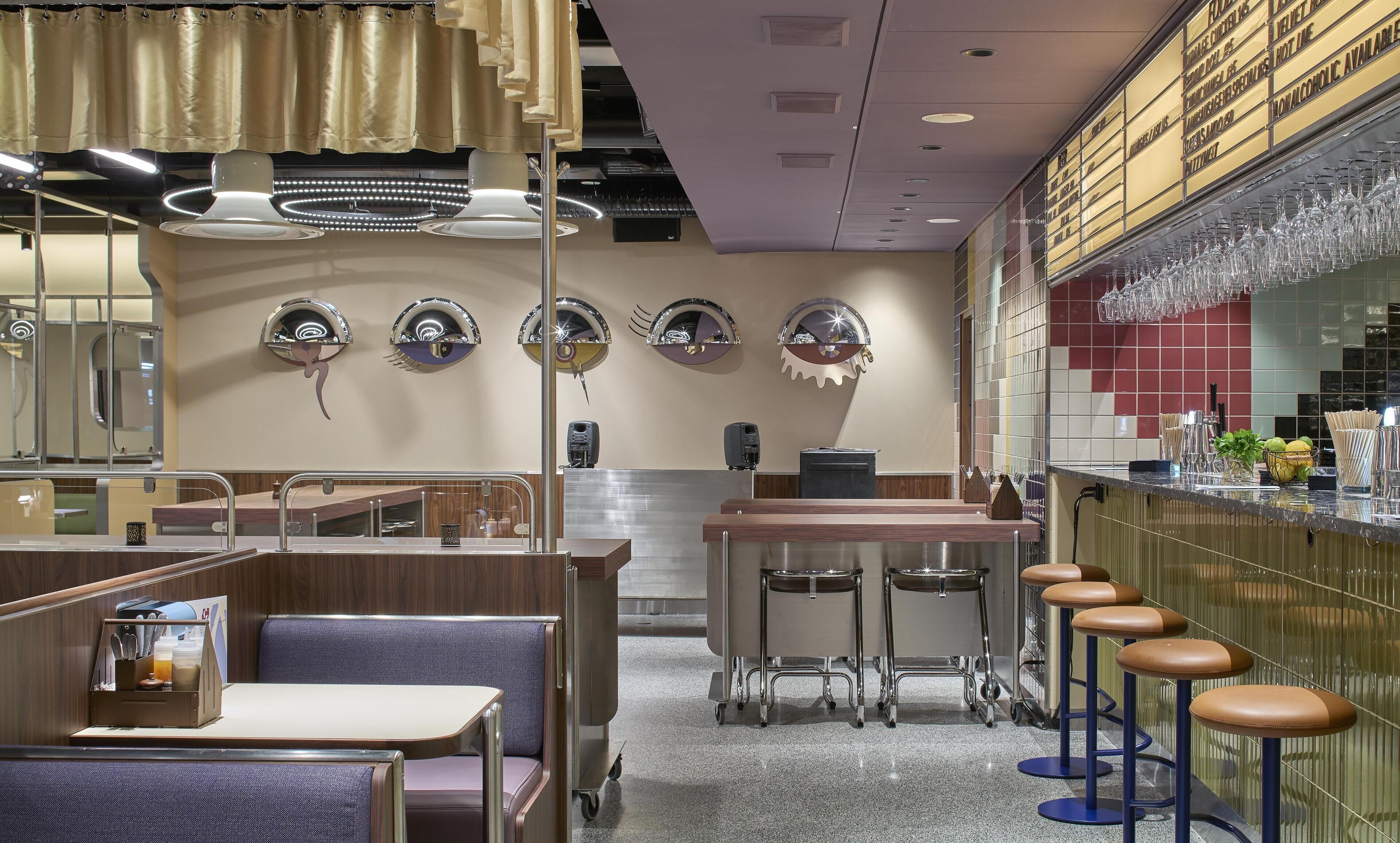 A restaurant interior with booths, a bar area, and a counter with stools.